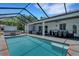 Inviting pool with screened-in patio, outdoor kitchen, and lounge area, providing the perfect space for entertaining at 1 Brogden Se Ct, Winter Haven, FL 33880
