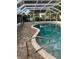 Inviting screened-in pool featuring a brick paver deck and clear, blue water at 1110 Cypress W Pt, Winter Haven, FL 33884