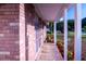 Exterior shot of brick building with a covered walkway, small flower beds, and trimmed hedges at 1160 Eleanore Ave, Bartow, FL 33830