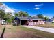 Inviting exterior of home featuring a carport, American flag, and well-manicured lawn at 1160 Eleanore Ave, Bartow, FL 33830