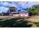 Charming single-story brick home with a well-manicured front lawn and traditional American flag at 1160 Eleanore Ave, Bartow, FL 33830