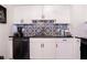 Well-lit kitchen with white cabinets, modern backsplash, and sleek black countertops at 1160 Eleanore Ave, Bartow, FL 33830