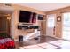 Bright living area featuring floating entertainment center, modern door, and wood laminate flooring at 1160 Eleanore Ave, Bartow, FL 33830