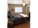 Cozy bedroom features neutral colored walls and a patterned quilt on the bed at 1208 W Lake Buckeye Dr, Winter Haven, FL 33881