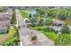 Aerial view of a gated community entrance showcasing a pool, playground, pond, and lush landscaping at 1215 Evergreen Park Cir, Lakeland, FL 33813