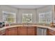 Kitchen sink with three windows overlooking the yard, matching wood cabinets and tile floors at 1215 Evergreen Park Cir, Lakeland, FL 33813