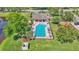 Aerial view of a community pool and playground surrounded by lush landscaping and a secure fence at 1215 Evergreen Park Cir, Lakeland, FL 33813