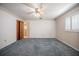 A bedroom featuring blue carpet, ceiling fan, and a window with white shutters at 1317 Old Polk City Rd, Lakeland, FL 33809