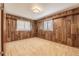 A small wood paneled bedroom featuring two windows with white shutters and neutral carpet at 1317 Old Polk City Rd, Lakeland, FL 33809