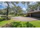 Brick home showcasing mature trees and spacious driveway at 1317 Old Polk City Rd, Lakeland, FL 33809