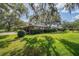 Brick home featuring a manicured side lawn and mature trees at 1317 Old Polk City Rd, Lakeland, FL 33809