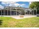 Spacious backyard featuring a screened patio, fire pit, and ample green space for outdoor enjoyment at 1328 Edgewater Beach Dr, Lakeland, FL 33805