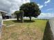A spacious green backyard with a large tree in view of the lake at 1328 Edgewater Beach Dr, Lakeland, FL 33805