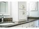 Bathroom vanity with dark counters, white cabinets, double sinks and large mirrors at 1328 Edgewater Beach Dr, Lakeland, FL 33805