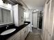 Bathroom with double sink vanity with black countertop and shower at 1328 Edgewater Beach Dr, Lakeland, FL 33805