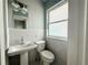 Elegant bathroom featuring a stylish pedestal sink, tiled walls, and a frosted window at 1328 Edgewater Beach Dr, Lakeland, FL 33805