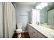 This bathroom features a shower with curtain, wood flooring, granite countertop and ample storage at 1328 Edgewater Beach Dr, Lakeland, FL 33805