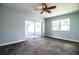 Carpeted bedroom with a ceiling fan, a sliding glass door, and a window at 1328 Edgewater Beach Dr, Lakeland, FL 33805