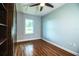 This simple bedroom has wood floors, a ceiling fan, a built in bookcase, and a window at 1328 Edgewater Beach Dr, Lakeland, FL 33805