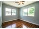 Bedroom with hardwood floors, ceiling fan and two windows offering natural light at 1328 Edgewater Beach Dr, Lakeland, FL 33805