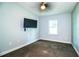 This simple bedroom features carpeted floors, a ceiling fan, and a wall-mounted television at 1328 Edgewater Beach Dr, Lakeland, FL 33805