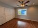 Bright bedroom with hardwood floors, fan and large built-in white storage cabinets, and window at 1328 Edgewater Beach Dr, Lakeland, FL 33805