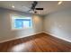 Bright bedroom features hardwood floors, a ceiling fan, and a large window at 1328 Edgewater Beach Dr, Lakeland, FL 33805