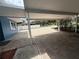 Wide carport with brick paving offering generous covered parking and access to the blue house at 1328 Edgewater Beach Dr, Lakeland, FL 33805