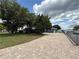 Charming blue home featuring a brick driveway, mature trees, and partial water view at 1328 Edgewater Beach Dr, Lakeland, FL 33805