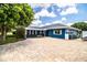 Charming blue home features a brick driveway, carport, and well-maintained landscaping at 1328 Edgewater Beach Dr, Lakeland, FL 33805