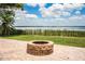 Outdoor fire pit area on a brick patio with a beautiful water view and lush green lawn at 1328 Edgewater Beach Dr, Lakeland, FL 33805