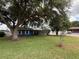 Charming blue home set back on a lush green lawn with mature trees and tidy landscaping at 1328 Edgewater Beach Dr, Lakeland, FL 33805