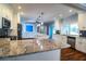 Bright kitchen with white cabinets and granite counters, showing view to additional island and Gathering room at 1328 Edgewater Beach Dr, Lakeland, FL 33805