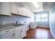 Large laundry room with white cabinets, granite countertops, and wood floors at 1328 Edgewater Beach Dr, Lakeland, FL 33805