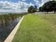 Waterfront lawn featuring a manicured green lawn with a chain link fence and lake views at 1328 Edgewater Beach Dr, Lakeland, FL 33805