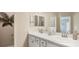 Bright bathroom features dual sinks, white cabinets, and a large mirror at 1368 Melrose St, Lake Alfred, FL 33850