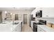 Modern kitchen with stainless appliances, white cabinetry, large island with seating and pendant lighting at 1368 Melrose St, Lake Alfred, FL 33850
