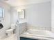 Bathroom with a built-in tub, tiled walls, and vanity with a decorative mirror at 1405 Clinton St, Bartow, FL 33830