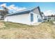 Side view of the home, featuring a well-maintained lawn, secure windows, and a glimpse of the backyard at 1405 Clinton St, Bartow, FL 33830