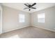 Bright bedroom featuring two windows, a ceiling fan, and carpet flooring at 1507 Holly Rd, Lakeland, FL 33801
