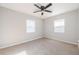 Bright bedroom with a ceiling fan and two large windows at 1507 Holly Rd, Lakeland, FL 33801