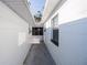 Exterior view of narrow walkway, enclosed by two white walls with a window and door on either side at 1507 Holly Rd, Lakeland, FL 33801
