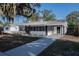 Bright single-story home with a covered porch, new walkway, and manicured lawn at 1507 Holly Rd, Lakeland, FL 33801