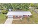 Aerial view of a brick home with a long driveway, attached garage and metal roof at 1507 Neptune Dr, Lakeland, FL 33801