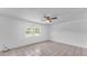 Bright bedroom featuring neutral tile flooring, a ceiling fan and a large window at 1507 Neptune Dr, Lakeland, FL 33801