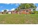 Charming brick home with a well-manicured lawn, attached garage, and mature landscaping at 1507 Neptune Dr, Lakeland, FL 33801