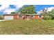 Charming brick home featuring a well-manicured lawn, attached garage, and traditional windows at 1507 Neptune Dr, Lakeland, FL 33801