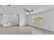 Bright living room featuring neutral tile flooring, a ceiling fan and an adjacent room at 1507 Neptune Dr, Lakeland, FL 33801