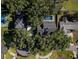 Aerial view of property featuring a private pool, tennis court, lush greenery, and well-maintained grounds at 1516 Jae Pl, Lakeland, FL 33803