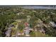Drone shot of the property nestled among mature trees, showcasing the pool, tennis court, and surrounding neighborhood at 1516 Jae Pl, Lakeland, FL 33803